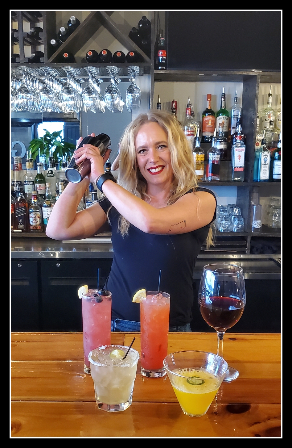 Brooke at the bar with an assortment of colorful drinks